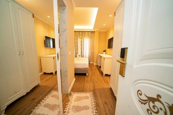 Innenansicht eines Zimmers im Vila Mare Hotel mit Doppelbett, Fernseher und Möbeln.