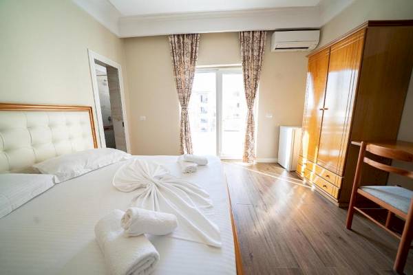 Schlafzimmer im Vila Mare Hotel mit einem Bett, weißen Handtüchern und einem Schrank.