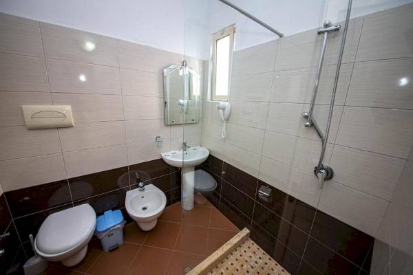 Vila Mare Hotel Badezimmer mit Toilette, Bidet, Waschbecken und Dusche.