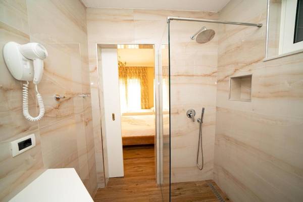 Vila Mare Hotel Badezimmer mit Marmorwänden, Glasdusche und Haartrockner