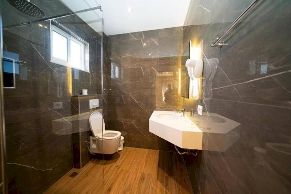 Badezimmer im Vila Mare Hotel mit Dusche, Toilette und Waschbecken.