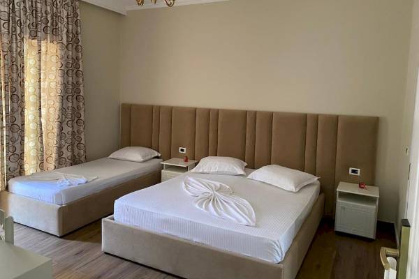 Doppelzimmer im Vila Mare Hotel mit zwei Betten, Nachttischen und einer Lampe.