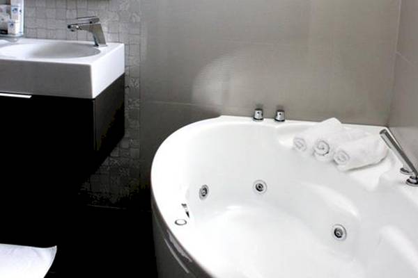 Badezimmer mit Badewanne im Demi Hotel
