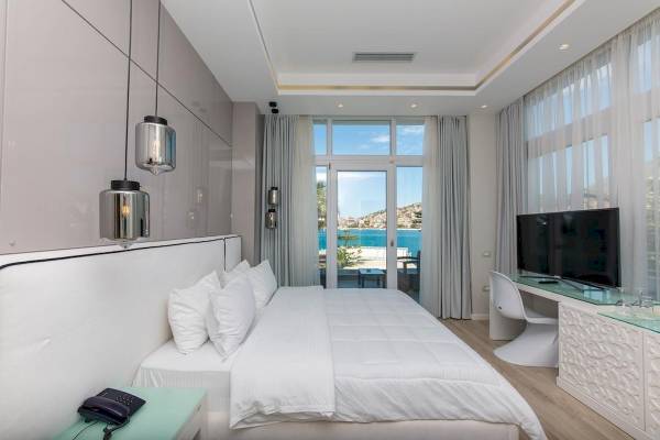 Schlafzimmer im Demi Hotel mit Meerblick, modernes Design, weiße Möbel und große Fenster.