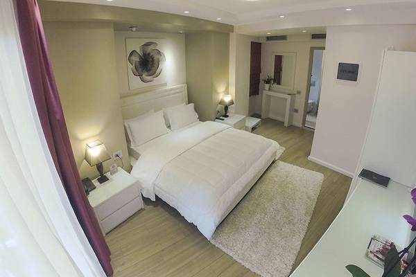 Schlafzimmer im Demi Hotel mit einem großen Bett, zwei Nachttischen und Lampen.