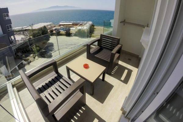 Balkon des Demi Hotels mit Blick auf das Meer und einen kleinen Tisch mit roten Dekorationen.