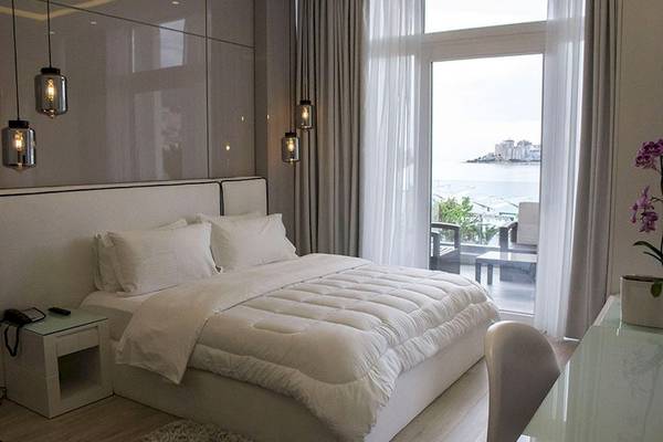 Schlafzimmer im Demi Hotel mit Blick auf den Ozean und modernem Design.