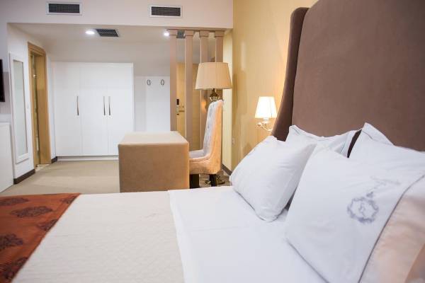 Hotelzimmer im Santa Quaranta Premium Resort mit Bett, Schreibtisch, Stühlen und Lampen.