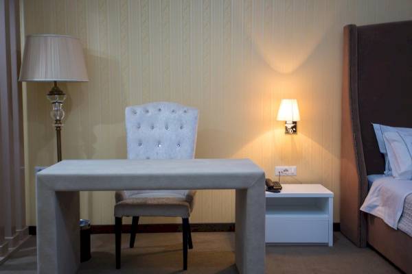 Hotelzimmer im Santa Quaranta Premium Resort mit Schreibtisch, Stuhl und Nachttisch.