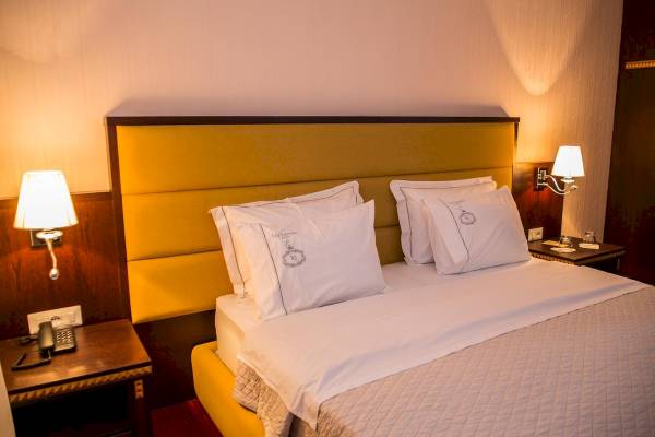 Hotelzimmer mit einem Bett, Kissen und zwei Nachttischen