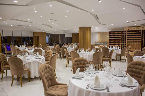 Restaurant des Santa Quaranta Premium Resorts mit eingerichteten Tischen und Stühlen.