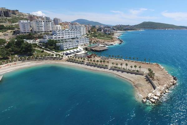 Luftaufnahme des Santa Quaranta Premium Resorts am Meer mit weißen Gebäuden und Palmen