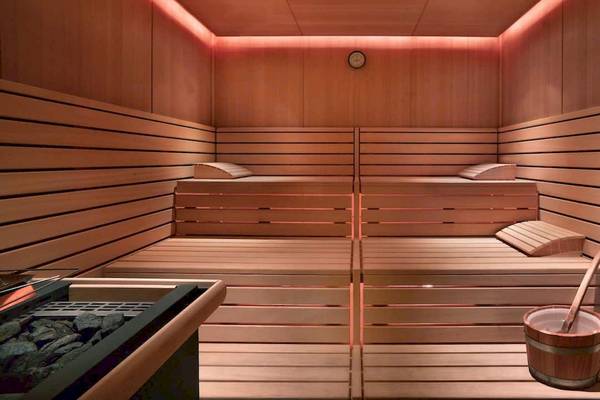 Innenansicht einer Sauna im Grand Hyatt Dubai mit Holzwänden, Liegen und einem Eimer.