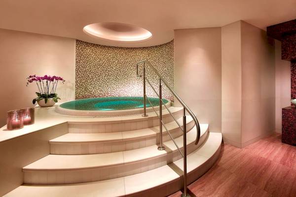 Innenbereich des Grand Hyatt Dubai Spa mit einer gefliesten Badewanne und Marmortreppe.