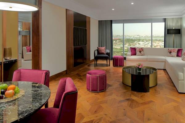 Wohnzimmer im Grand Hyatt Dubai mit großer Couch, Esstisch und modernem Dekor.