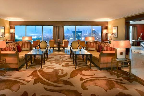 Ansicht des Grand Hyatt Dubai Lobbys mit Sofas, Tischen und Blick auf die Stadt