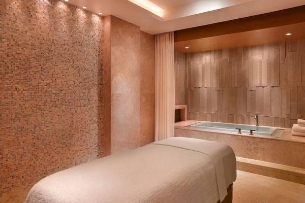 Wellnessbereich im Grand Hyatt Dubai mit einer Badewanne und einem Behandlungstisch.