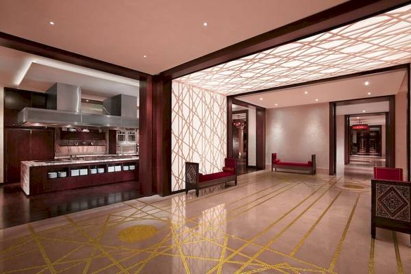 Innenbereich der Lobby des Grand Hyatt Dubai mit geometrischen Mustern und roten Bänken.