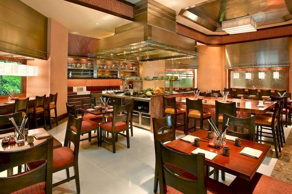 Innenansicht des Restaurants im Grand Hyatt Dubai mit gedeckten Tischen und Stühlen.