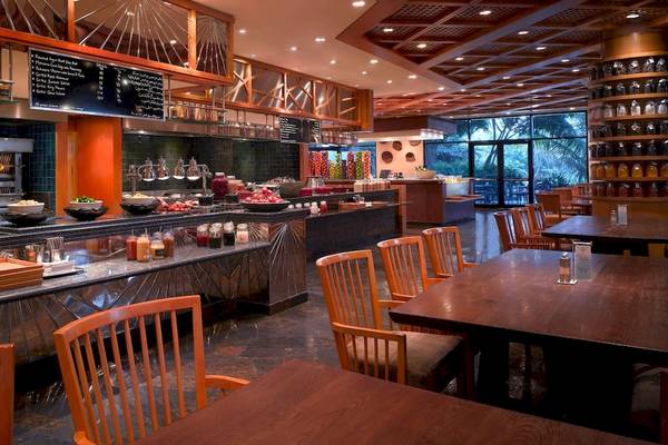 Innenansicht des Restaurants im Grand Hyatt Dubai mit gebratenen Gerichten und Sitzbereichen.