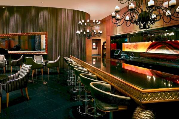 Loungebereich im Grand Hyatt Dubai Hotel mit Klavier, Stühlen und Bar.