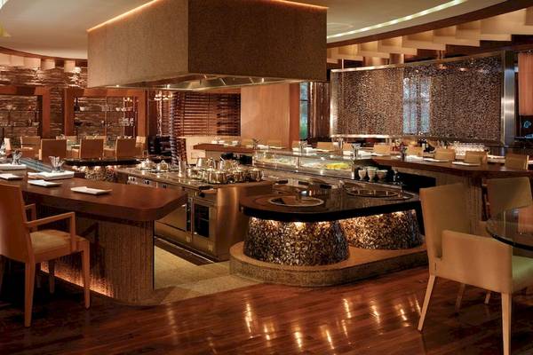 Innenansicht des Grand Hyatt Dubai Restaurants mit Holzböden, modernen Möbeln und einer langen Theke.