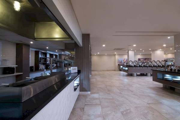 Innenansicht des Restaurants im Emotions By Hodelpa Hotel in Puerto Plata mit Edelstahltheken und Marmorboden.