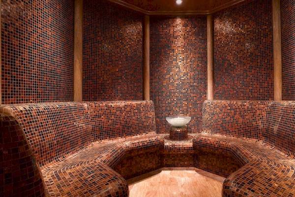 Innenansicht der Sauna im Grand Hyatt Dubai mit gefliesten Wänden und Bänken.