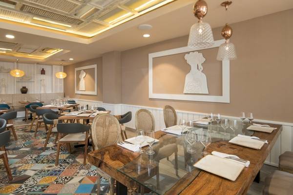 Innenbereich des Restaurants im Emotions By Hodelpa Hotel in Puerto Plata mit Tisch, Stühlen und dekorativen Elementen.