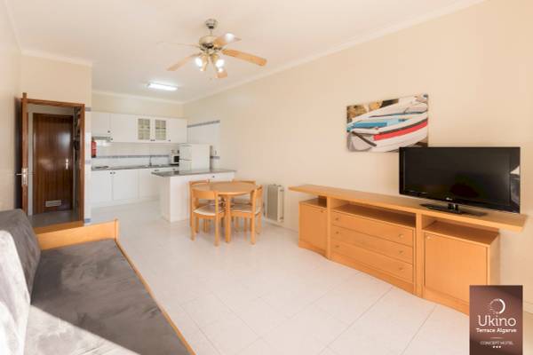 Inneneinrichtung des Ukino Terrace Algarve Hotels mit Wohnzimmer, Tisch, Fernseher und Küche