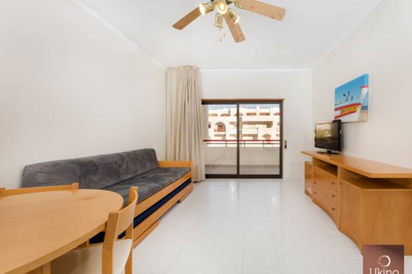 Wohnzimmer im Ukino Terrace Algarve Hotel mit Sofa, Tisch, Fernseher und Deckenventilator