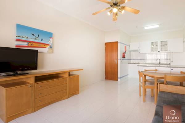 Inneneinrichtung des Ukino Terrace Algarve mit Wohnzimmer, Esstisch, Fernseher und Küche