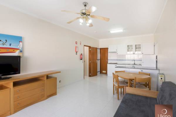 Innenbereich des Ukino Terrace Algarve Hotels mit Wohnzimmer, Küche und Esstisch.