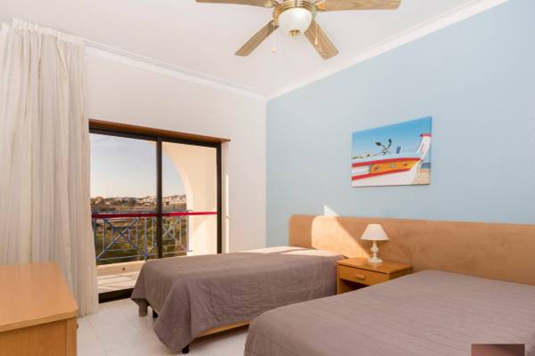 Zwei Betten mit Aussicht auf die Stadt im Ukino Terrace Algarve Hotelzimmer.