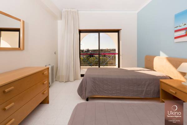 Doppelzimmer im Ukino Terrace Algarve Hotel mit zwei Betten, Blick auf Terrasse und Landschaft