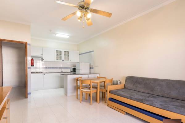 Wohnzimmer im Ukino Terrace Algarve Hotel mit Esstisch, Sofa und offener Küche.