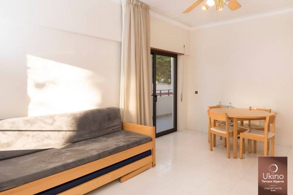Wohnzimmer im Ukino Terrace Algarve Hotel mit Schlafsofa, Esstisch und Balkon
