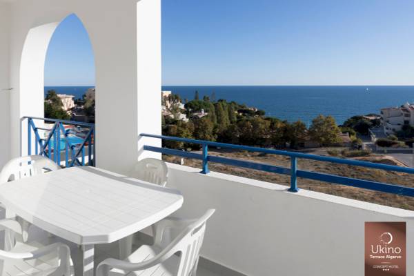 Balkon mit Tisch und Stühlen mit Blick auf das Meer und eine Stadt, Ukino Terrace Algarve