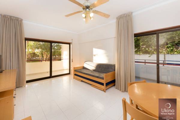 Wohnzimmer im Ukino Terrace Algarve mit Sofa, Tisch und Stühlen.