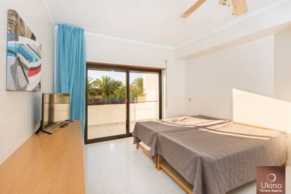 Schlafzimmer im Ukino Terrace Algarve Hotel mit zwei Betten, Fernseher und Balkon