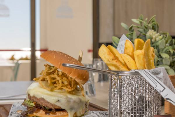 Ein Burger mit Pommes auf einem Tisch im Ukino Terrace Algarve Hotel.