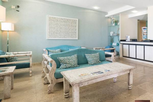 Loungebereich des Ukino Terrace Algarve Hotels mit blauen Sofas und einem weißen Tisch.