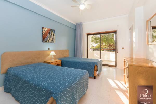 Doppelzimmer im Ukino Terrace Algarve mit zwei Betten, Klimaanlage und Terrassenzugang.