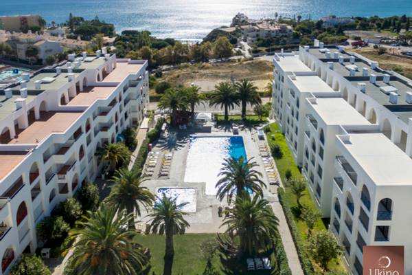 Außenansicht des Ukino Terrace Algarve Hotels mit Swimmingpool und Meer im Hintergrund.