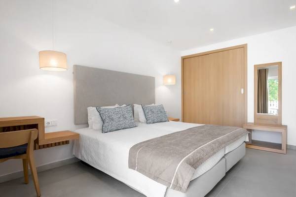 Hotelzimmer im Ancora Park mit weißem Bett, grauen Kissen und heller Einrichtung.
