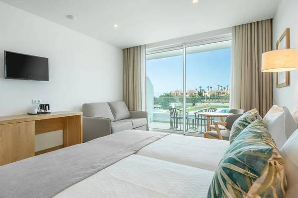 Doppelzimmer im Ancora Park Hotel mit Bett, Sofa, Fernseher und Terrassenblick.