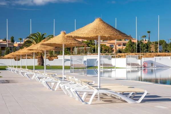 Mehrere Sonnenliegen stehen neben einem Pool im Hotel Ancora Park.