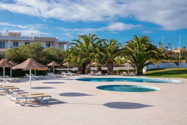 Außenpoolbereich des Ancora Park Hotels mit Liegen und Sonnenschirmen.