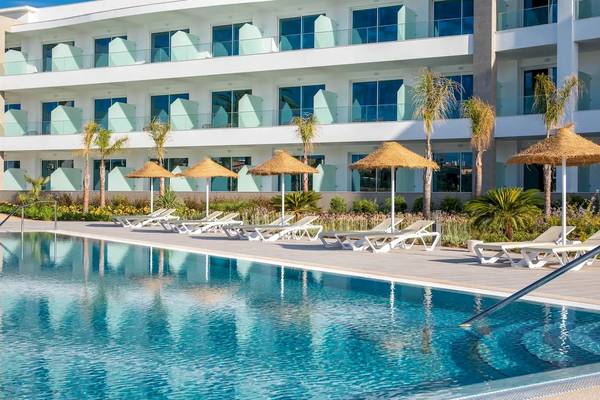Außenpool des Ancora Park Hotels mit Sonnenliegen und Sonnenschirmen.