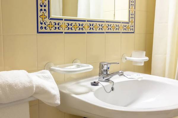 Badezimmer im Pedras da Rainha Resort mit Waschbecken und Handtüchern.